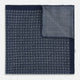 The Rosette Navy Pocket Square in Silk by Turnbull & Asser UK is a square, navy blue accessory featuring a small geometric pattern. Shown laid flat with one corner folded, it reveals a contrasting, finer motif on the reverse side. This elegant double-sided design offers versatile styling options for any occasion.