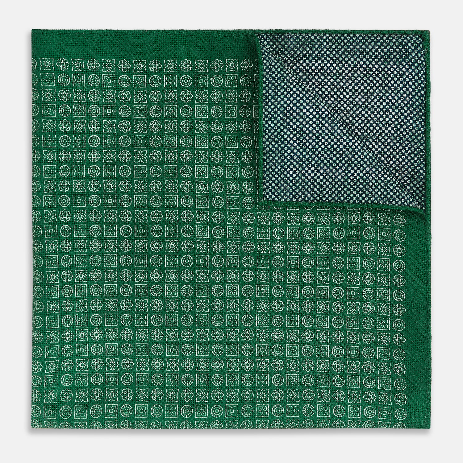 View 4 of product The Rosette Green Pocket Square in Silk by Turnbull & Asser UK features a small geometric medallion pattern and is shown folded to display a contrasting fine black-and-white design on the reverse side.