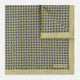 The Rosette Yellow Pocket Square in Silk by Turnbull & Asser UK features a square design with a yellow border, adorned with a grid of small black and white circles. One corner is neatly folded to reveal a reverse side in a refined black and white micro-checkered pattern, while subtle geometric medallions lend an added touch of elegance to the overall look.