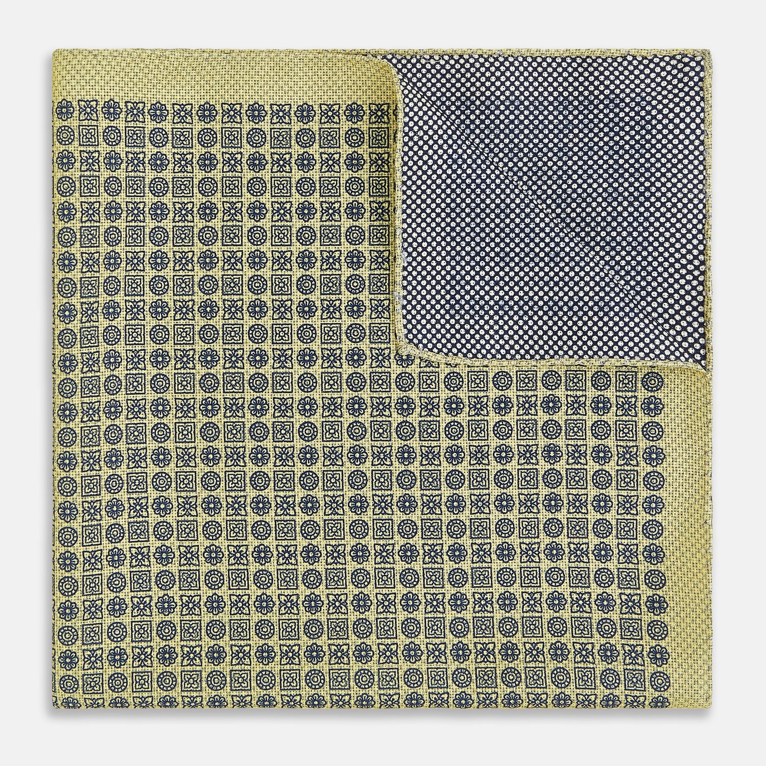 View 4 of product The Rosette Yellow Pocket Square in Silk by Turnbull & Asser UK features a square design with a yellow border, adorned with a grid of small black and white circles. One corner is neatly folded to reveal a reverse side in a refined black and white micro-checkered pattern, while subtle geometric medallions lend an added touch of elegance to the overall look.