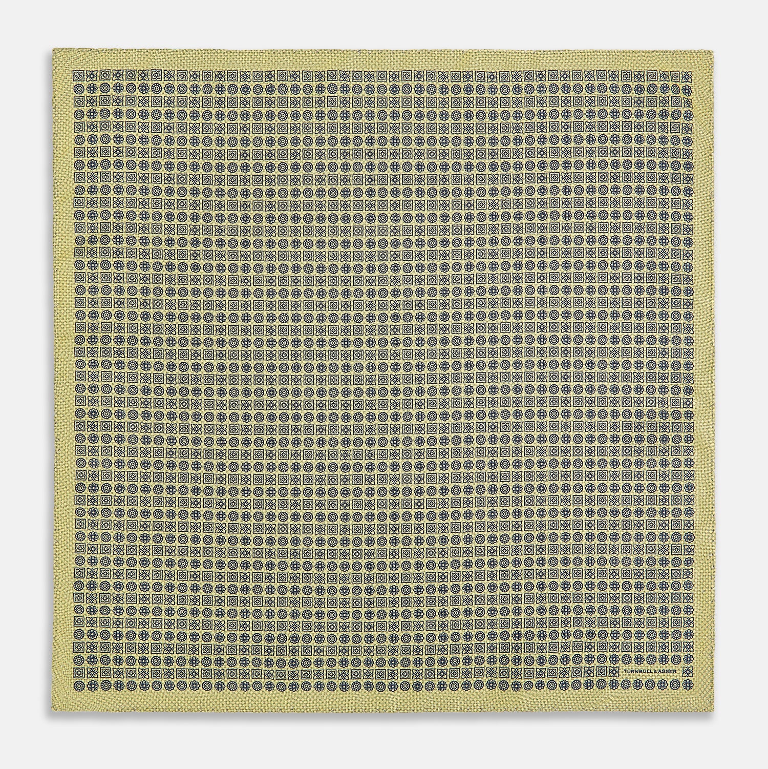 View 5 of product The Rosette Yellow Pocket Square in Silk by Turnbull & Asser UK features a square design with a yellow border, adorned with a grid of small black and white circles. One corner is neatly folded to reveal a reverse side in a refined black and white micro-checkered pattern, while subtle geometric medallions lend an added touch of elegance to the overall look.