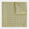 View 1 of product A yellow silk pocket square featuring a small black grid pattern of dotted squares, neatly folded at one corner. "Turnbull & Asser UK" is printed in the bottom right corner.