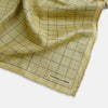View 2 of product A yellow silk pocket square featuring a small black grid pattern of dotted squares, neatly folded at one corner. "Turnbull & Asser UK" is printed in the bottom right corner.