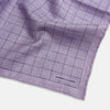 View 3 of product The Checked Lilac Pocket Square in Silk by Turnbull & Asser UK features a grid pattern in purple with a solid border, neatly folded to display its double-sided design and contrasting black and white dotted squares on the reverse side.