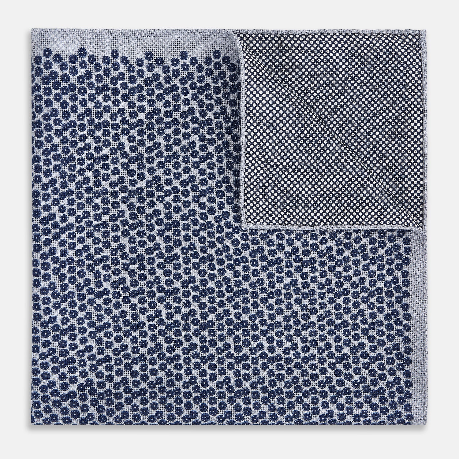 View 4 of product The Turnbull & Asser UK Floral Blue Pocket Square in Silk showcases a refined double-sided design, with a clustered dot pattern in blue and white on the front and a delicate fine dotted motif on the back. Presented with one corner elegantly folded, it exudes sophisticated style.