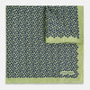 View 2 of product The Turnbull & Asser UK Floral Green Pocket Square in Silk is a square accessory featuring a blue floral pattern with a green border, partly folded at one corner to showcase its double-sided design, revealing a navy and light green dotted pattern on the reverse.