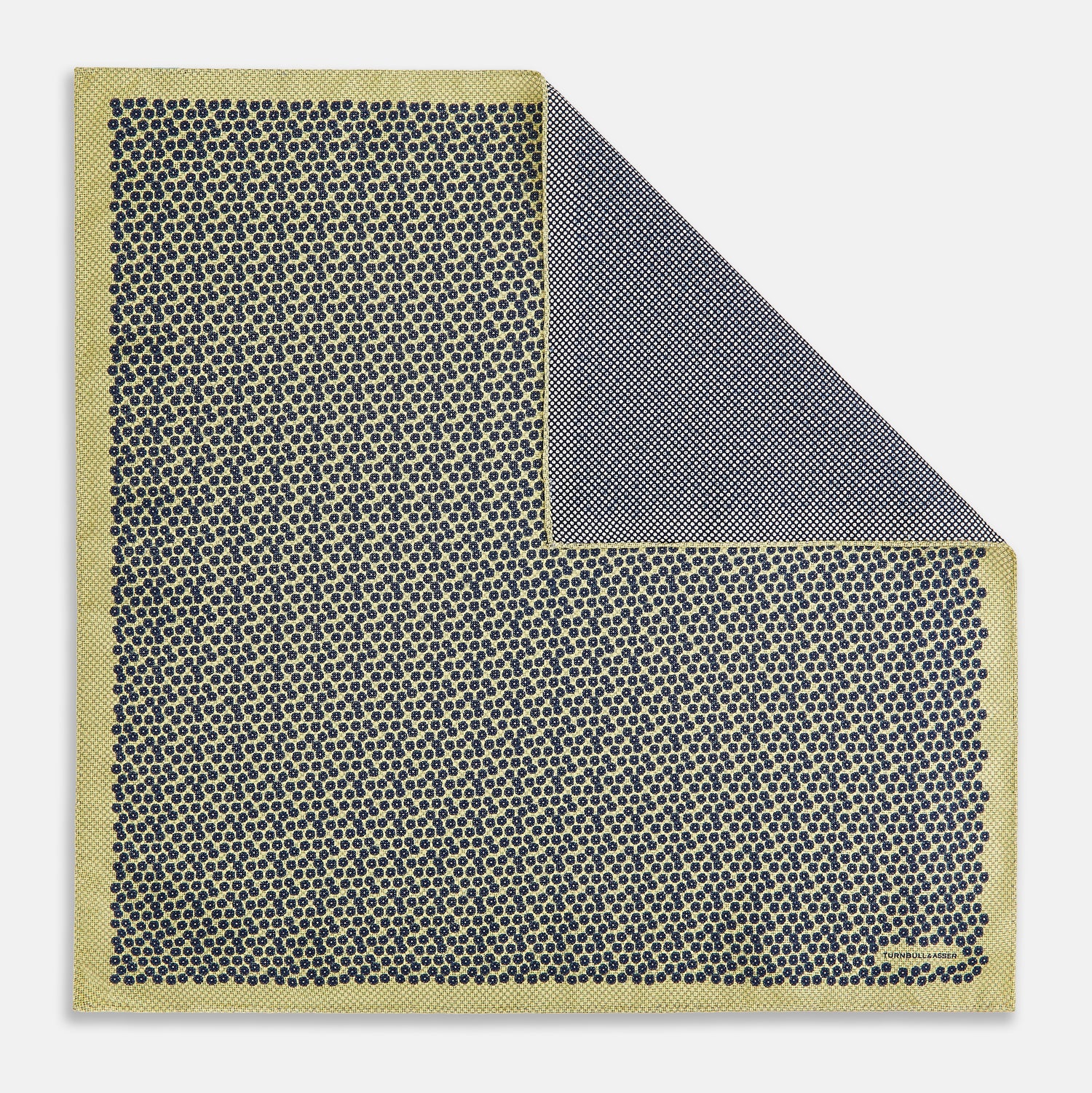 View 1 of product Introducing the Floral Yellow Pocket Square in Silk by Turnbull & Asser UK—a sophisticated square accessory featuring a vibrant yellow border and a black-and-white geometric dot pattern. One corner is tastefully folded to reveal its double-sided design, showcasing a smaller, denser dot motif on the reverse. Perfect for adding a modern touch of flair to any outfit or setting.