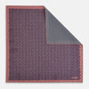 View 1 of product The Floral Pink Pocket Square in Silk by Turnbull & Asser UK showcases a refined pattern with a pink floral design and a contrasting border. The top right corner is elegantly folded to reveal the reverse side’s complementary blue and white dotted motif, emphasizing its double-sided versatility.