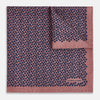 View 2 of product The Floral Pink Pocket Square in Silk by Turnbull & Asser UK showcases a refined pattern with a pink floral design and a contrasting border. The top right corner is elegantly folded to reveal the reverse side’s complementary blue and white dotted motif, emphasizing its double-sided versatility.