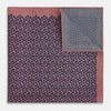 View 4 of product The Floral Pink Pocket Square in Silk by Turnbull & Asser UK showcases a refined pattern with a pink floral design and a contrasting border. The top right corner is elegantly folded to reveal the reverse side’s complementary blue and white dotted motif, emphasizing its double-sided versatility.