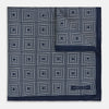 View 2 of product Introducing the Geometric Navy Tile Pocket Square in Silk by Turnbull & Asser UK—a folded navy and white accessory showcasing a double-sided design, with one side featuring concentric squares that form a striking geometric pattern and the other adorned with an elegant small dot motif.