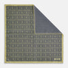 View 1 of product The Turnbull & Asser UK Geometric Yellow Tile Pocket Square in Silk features a sophisticated geometric square pattern in gold and navy, accented with subtle concentric squares and a discreet label stitched into the bottom right corner. Its double-sided design is highlighted by a folded corner that reveals a contrasting dotted navy and white underside.