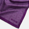 View 3 of product The Turnbull & Asser UK Geometric Purple Tile Pocket Square in Silk features a vibrant purple hue adorned with concentric square motifs. One corner is folded to reveal its double-sided design, showcasing a contrasting black-and-white dotted underside.