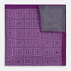View 4 of product The Turnbull & Asser UK Geometric Purple Tile Pocket Square in Silk features a vibrant purple hue adorned with concentric square motifs. One corner is folded to reveal its double-sided design, showcasing a contrasting black-and-white dotted underside.