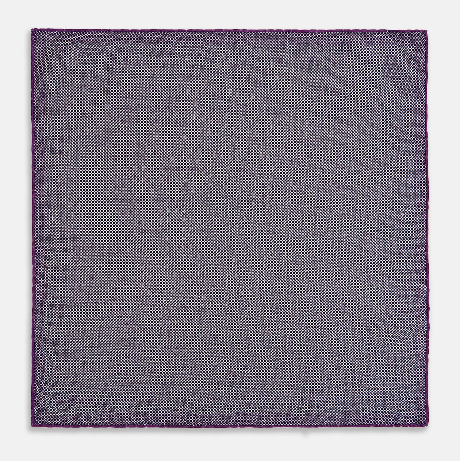 View 6 of product The Turnbull & Asser UK Geometric Purple Tile Pocket Square in Silk features a vibrant purple hue adorned with concentric square motifs. One corner is folded to reveal its double-sided design, showcasing a contrasting black-and-white dotted underside.