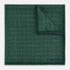 The Geometric Green Tile Pocket Square in Silk by Turnbull & Asser UK features a sophisticated tonal green design with a subtle pattern of concentric squares. One corner is folded to highlight the elegant double-sided construction, revealing a contrasting black and white small dot pattern on the reverse.