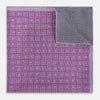 View 4 of product Certainly! Here’s a rewritten version of your sentence, incorporating the product data: The Geometric Lilac Tile Pocket Square in Silk by Turnbull & Asser UK features a lilac purple geometric pattern with a subtle square design, partially folded to reveal its double-sided construction with a contrasting black and white dotted pattern on the reverse.