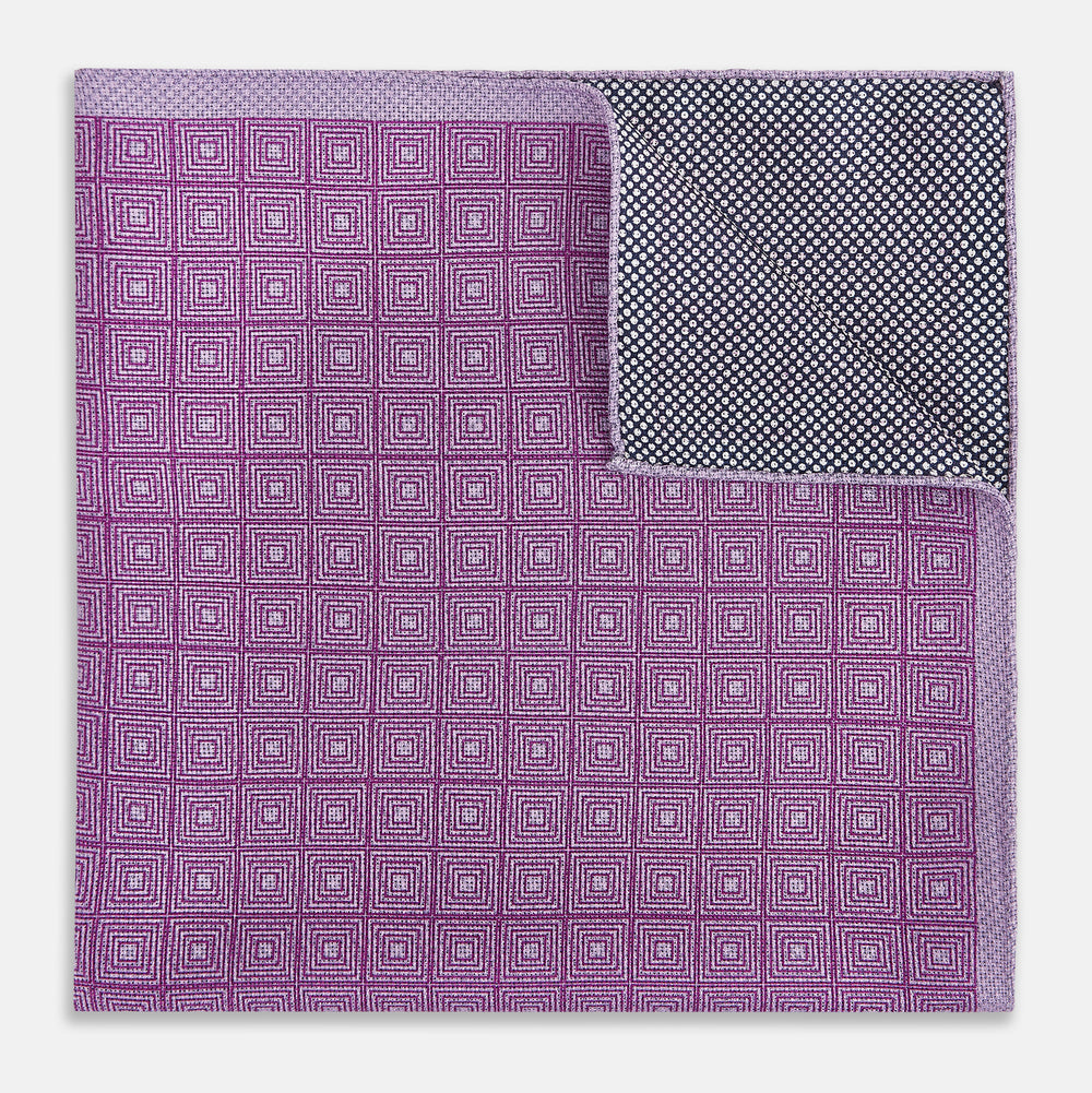 Certainly! Here’s a rewritten version of your sentence, incorporating the product data: The Geometric Lilac Tile Pocket Square in Silk by Turnbull & Asser UK features a lilac purple geometric pattern with a subtle square design, partially folded to reveal its double-sided construction with a contrasting black and white dotted pattern on the reverse.