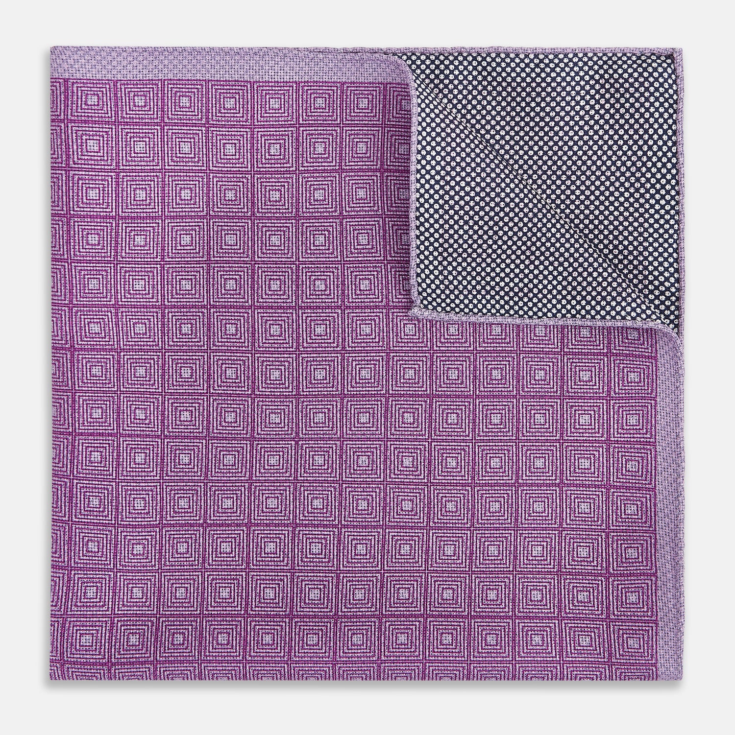 View 4 of product Certainly! Here’s a rewritten version of your sentence, incorporating the product data: The Geometric Lilac Tile Pocket Square in Silk by Turnbull & Asser UK features a lilac purple geometric pattern with a subtle square design, partially folded to reveal its double-sided construction with a contrasting black and white dotted pattern on the reverse.