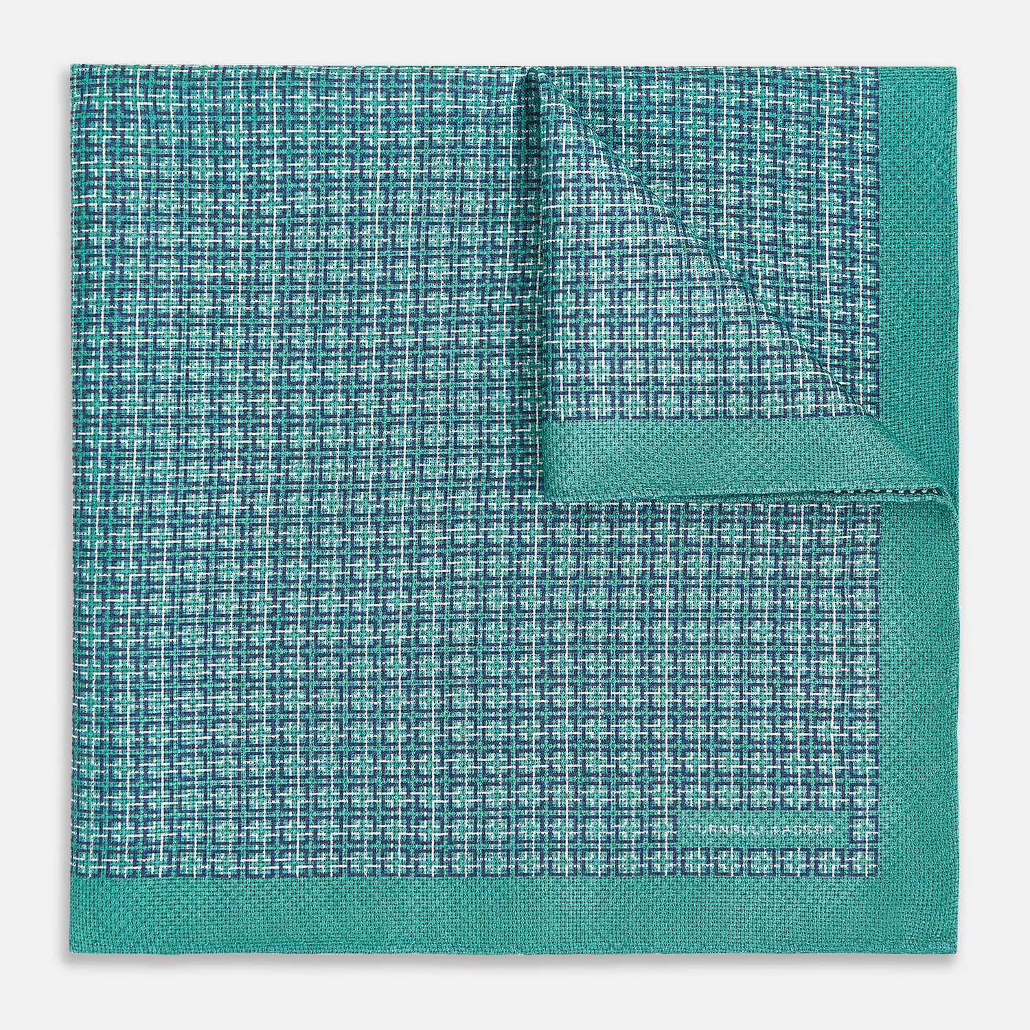 View 2 of product A geometric green silk pocket square by Turnbull & Asser UK, featuring a subtle houndstooth weave with a teal border, and partially folded to reveal a contrasting black and white micro-dot reverse pattern.
