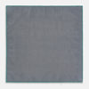 View 6 of product A geometric green silk pocket square by Turnbull & Asser UK, featuring a subtle houndstooth weave with a teal border, and partially folded to reveal a contrasting black and white micro-dot reverse pattern.