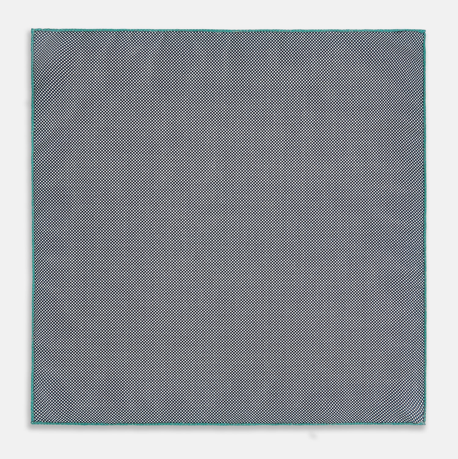 View 6 of product A geometric green silk pocket square by Turnbull & Asser UK, featuring a subtle houndstooth weave with a teal border, and partially folded to reveal a contrasting black and white micro-dot reverse pattern.