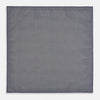 View 6 of product The Geometric Blue Pocket Square in Silk from Turnbull & Asser UK showcases a blue border and double-sided design, with a geometric pattern at the center. A folded corner reveals a refined, tighter dot motif on the reverse side, emphasizing the intricate craftsmanship of this finely woven accessory.