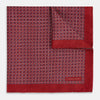 View 2 of product Turnbull & Asser UK’s Geometric Red Pocket Square in Silk features a small white checkered pattern and a cleverly flipped corner to showcase its contrasting black and white micro-dot reverse design.