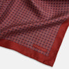 View 3 of product Turnbull & Asser UK’s Geometric Red Pocket Square in Silk features a small white checkered pattern and a cleverly flipped corner to showcase its contrasting black and white micro-dot reverse design.