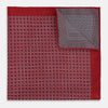 View 4 of product Turnbull & Asser UK’s Geometric Red Pocket Square in Silk features a small white checkered pattern and a cleverly flipped corner to showcase its contrasting black and white micro-dot reverse design.