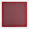 View 5 of product Turnbull & Asser UK’s Geometric Red Pocket Square in Silk features a small white checkered pattern and a cleverly flipped corner to showcase its contrasting black and white micro-dot reverse design.