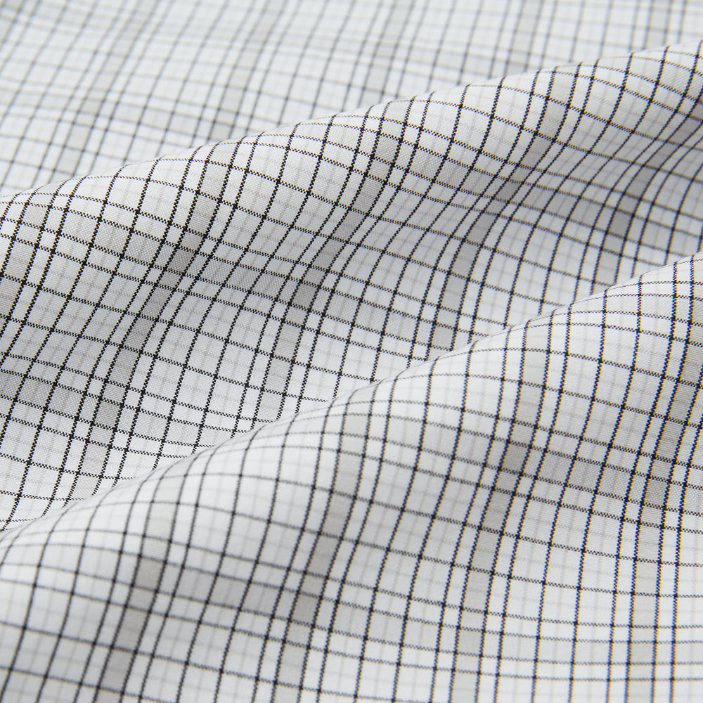 The Turnbull & Asser Grey Fine Multi Graph Check Pyjama Shirt features light grey and white checks, a single chest pocket, and long sleeves—ideal for stylish nightwear or as a classic pyjama shirt. Shown on a white background.
