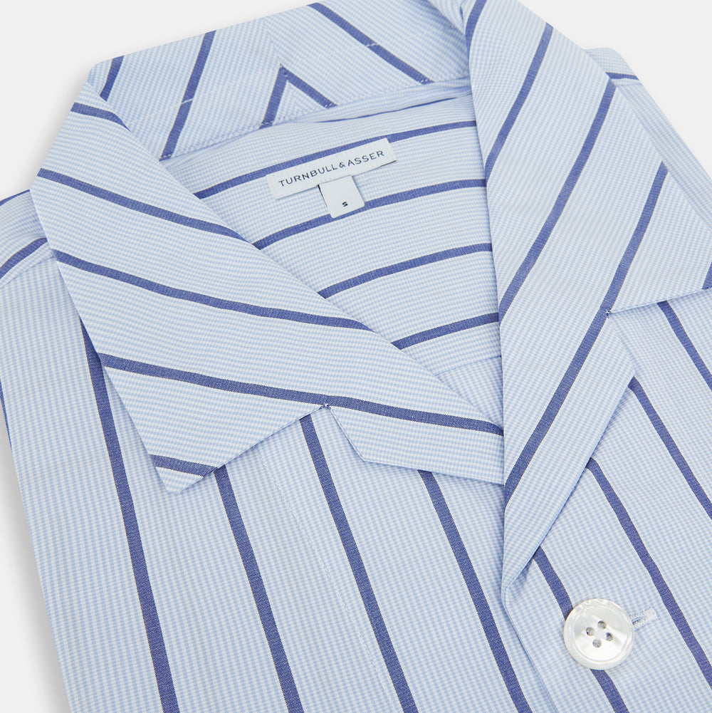 The Turnbull & Asser Blue Track Stripe Pyjama Shirt features a collar, white buttons, chest pocket, and vertical navy stripes—an elegant and comfortable loungewear option perfect for stylish nightwear.