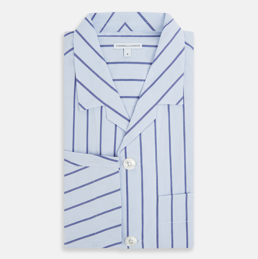 The Turnbull & Asser Blue Track Stripe Pyjama Shirt features a collar, white buttons, chest pocket, and vertical navy stripes—an elegant and comfortable loungewear option perfect for stylish nightwear.