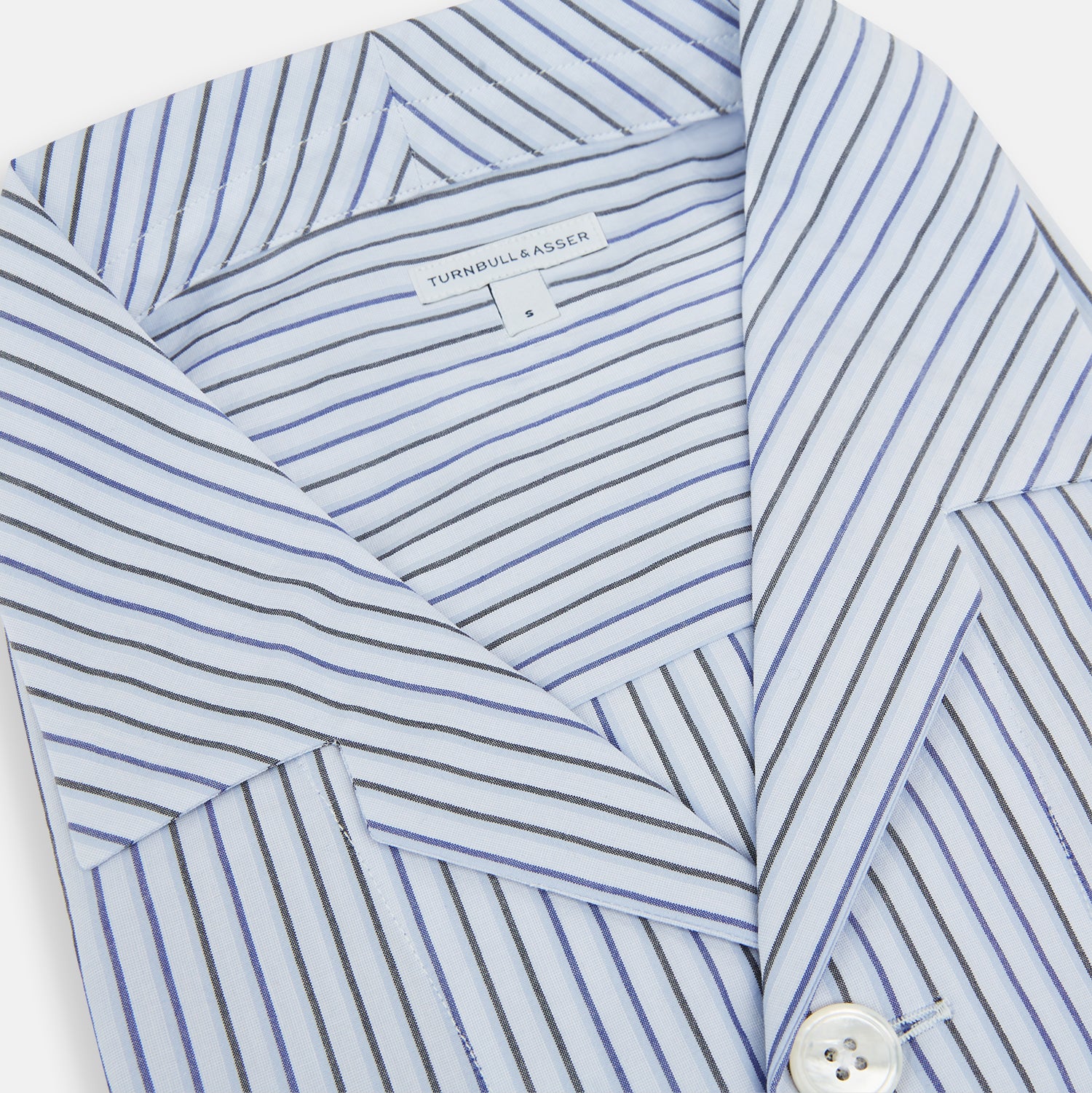 View 2 of product The Turnbull & Asser Blue Shadow Pinstripe Pyjama Shirt features blue and white vertical stripes, a chest pocket, and long sleeves—ideal for elegant homewear, shown against a white background.