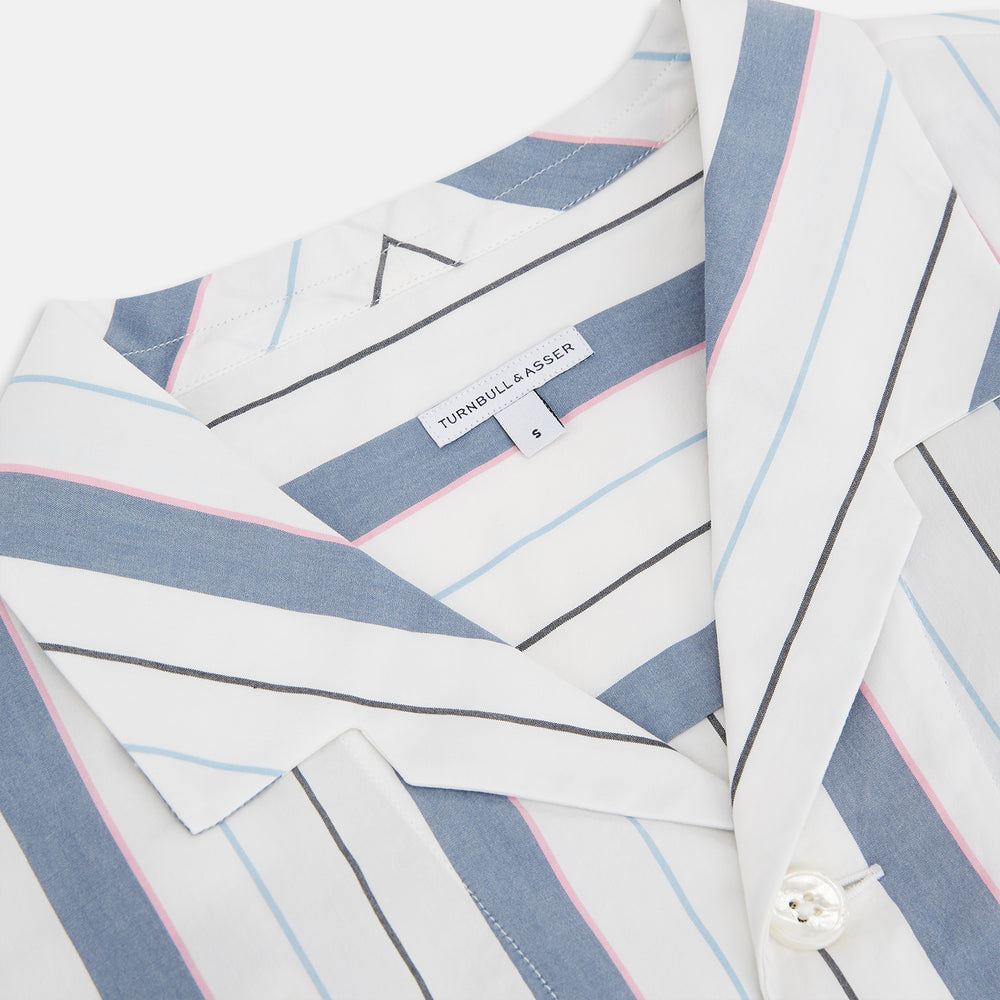 The Turnbull & Asser Blue Blazer Stripe Pyjama Shirt features a collar, chest pocket, and vertical blue, white, and light red stripes—an elegant long-sleeve loungewear piece neatly displayed on a plain white background.