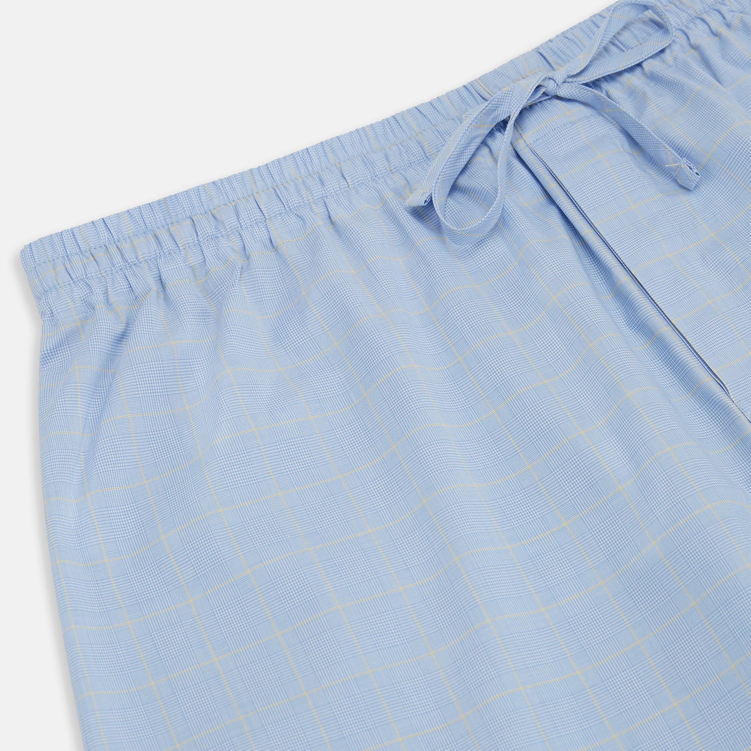 View 2 of product The Blue Prince of Wales Check Pyjama Trousers by Turnbull & Asser, featuring a subtle check pattern, elastic waistband, and drawstring tie, are laid flat on a white background.