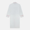 View 4 of product The Turnbull & Asser White Piped Herringbone Cotton Gown features long sleeves, a waist tie, chest pocket, and striking red piping on the collar, cuffs, pocket, and edges—an elegant piece showcased against a white background.