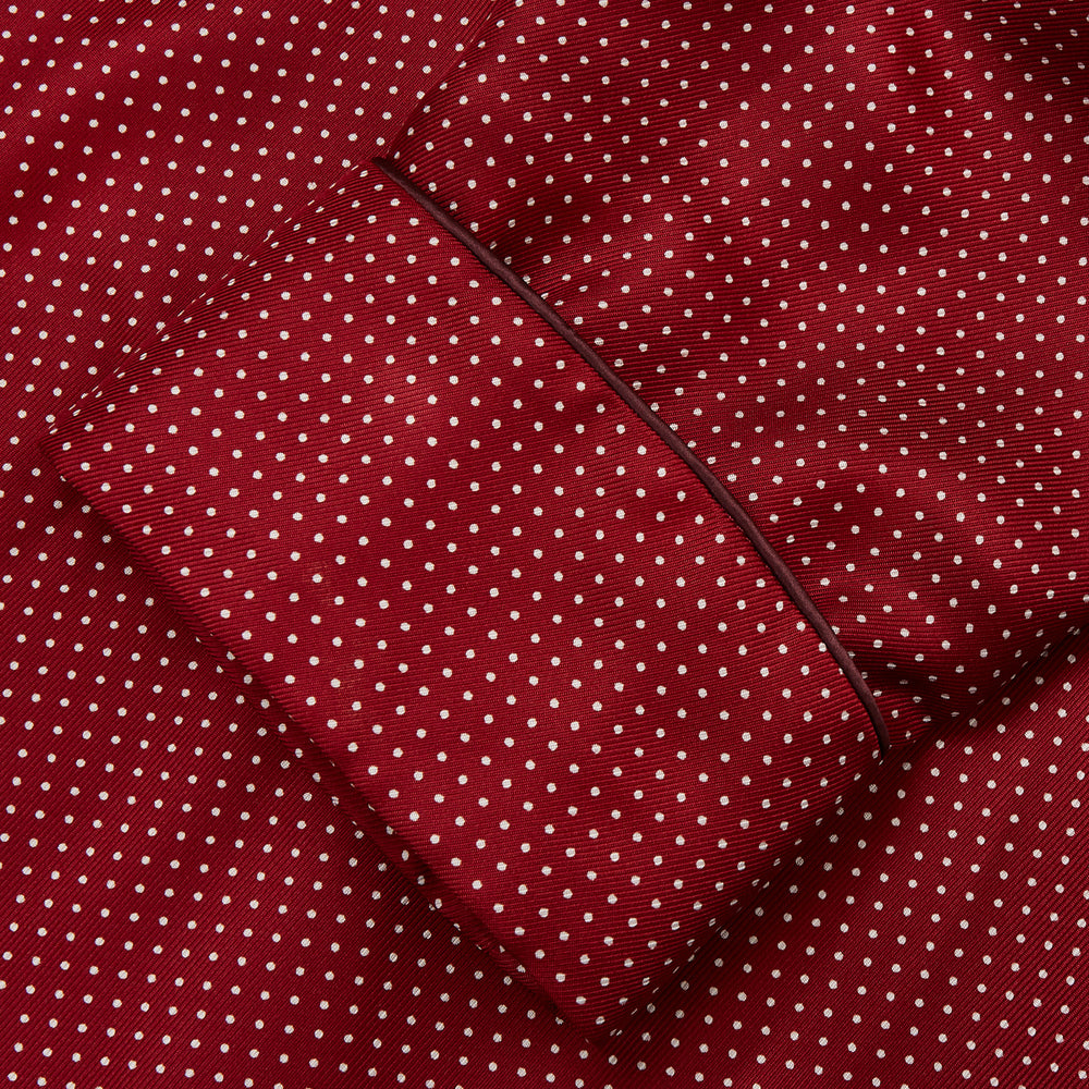 The Turnbull & Asser Burgundy Spot Silk Gown features a shawl collar, front pocket, and matching belt—ideal for relaxation—shown on a white background.