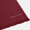 View 2 of product The Plain Wine Silk Scarf by Turnbull & Asser is a long, smooth accessory with subtle fringe and white Turnbull & Asser embroidery on one corner. It comes neatly folded in a deep wine color, perfect for an elegant touch.