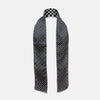 View 2 of product The Chequered Navy on White Frame Small Scarf in Silk by Turnbull & Asser UK is a long silk accessory featuring a classic black and white checkerboard pattern laid flat against a white background. Its ends are finished with a thin, fringed border, while the top edge is accented by diagonal stripes. The double-sided chequered design adds a stylish twist, with touches of navy and subtle hints of white bringing sophisticated detail to this timeless look.