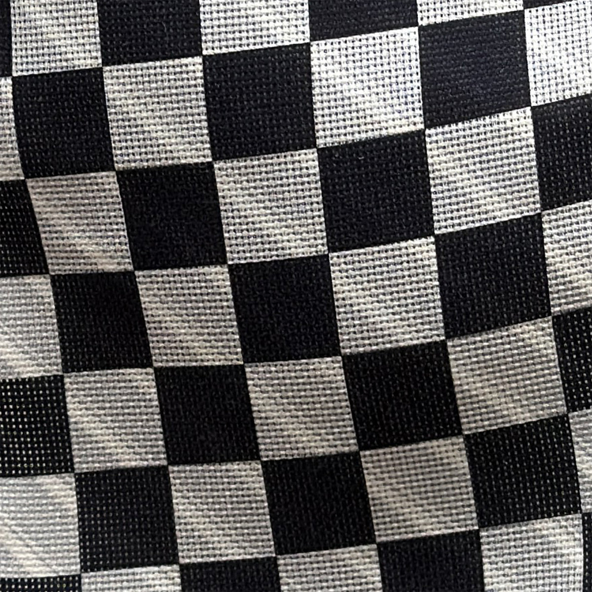View 4 of product The Chequered Navy on White Frame Small Scarf in Silk by Turnbull & Asser UK is a long silk accessory featuring a classic black and white checkerboard pattern laid flat against a white background. Its ends are finished with a thin, fringed border, while the top edge is accented by diagonal stripes. The double-sided chequered design adds a stylish twist, with touches of navy and subtle hints of white bringing sophisticated detail to this timeless look.