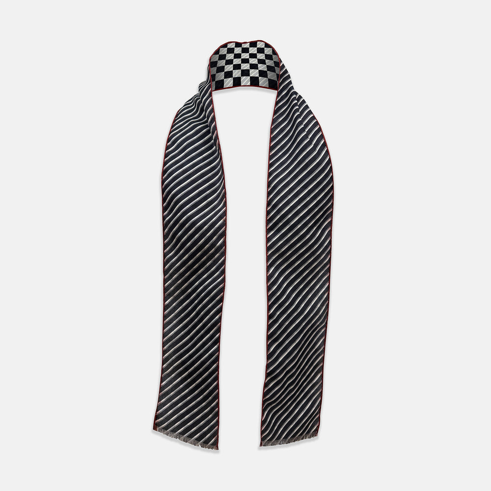 Introducing the Chequered Navy on Red Frame Small Scarf in Silk by Turnbull & Asser UK—a luxurious silk accessory featuring a navy and white chequered pattern, accented with thin red borders and delicate fringe at each end. Displayed against a white background, this scarf pays homage to British motoring heritage and the enduring elegance of Concours style.