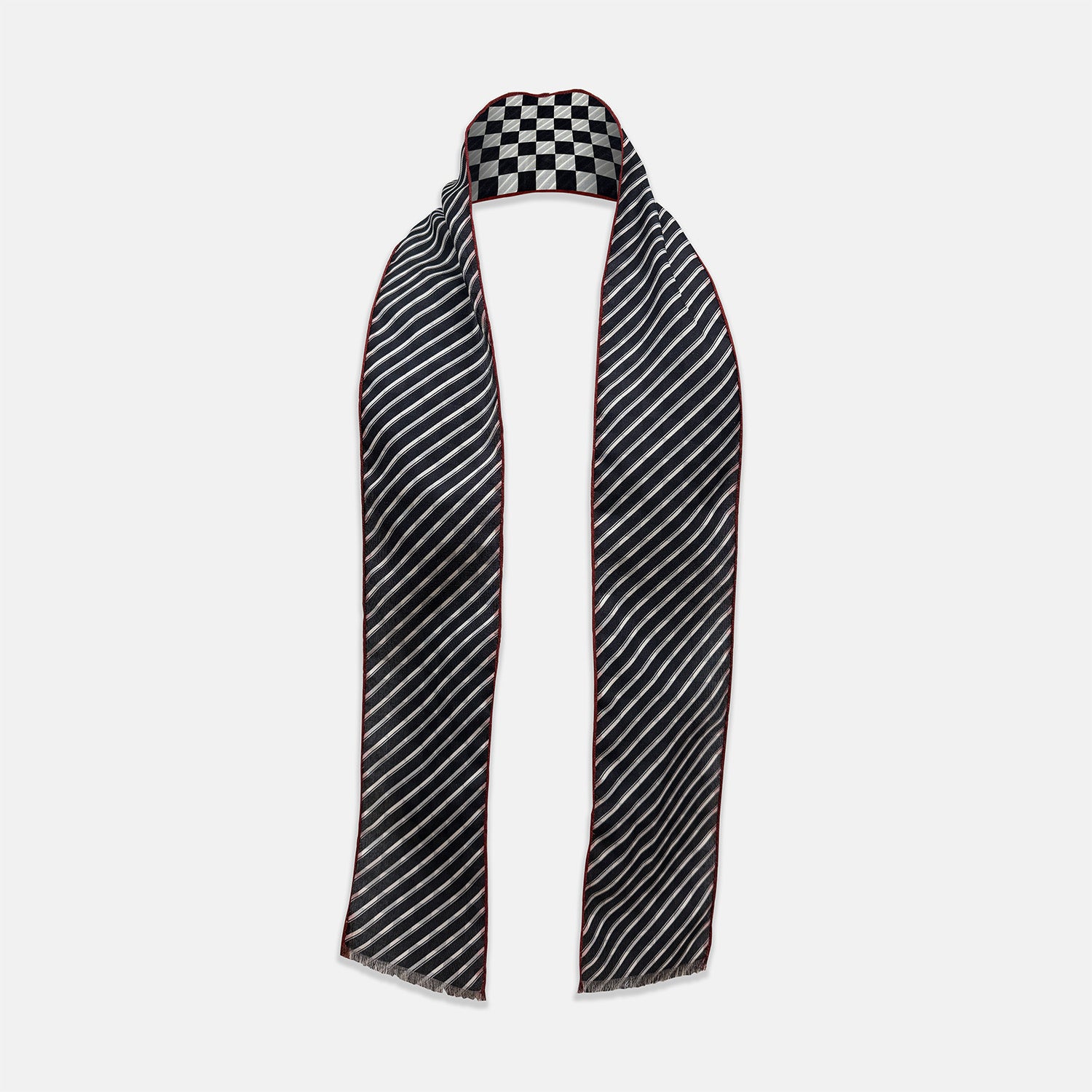 View 2 of product Introducing the Chequered Navy on Red Frame Small Scarf in Silk by Turnbull & Asser UK—a luxurious silk accessory featuring a navy and white chequered pattern, accented with thin red borders and delicate fringe at each end. Displayed against a white background, this scarf pays homage to British motoring heritage and the enduring elegance of Concours style.