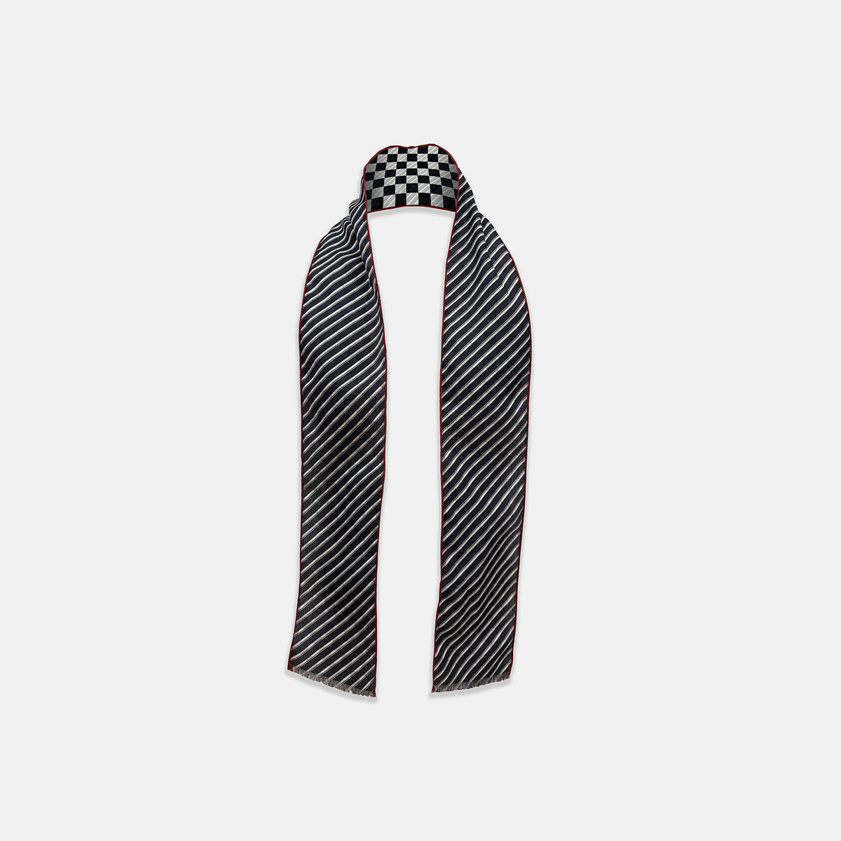 View 2 of product Introducing the Chequered Navy on Red Frame Small Scarf in Silk by Turnbull & Asser UK—a luxurious silk accessory featuring a navy and white chequered pattern, accented with thin red borders and delicate fringe at each end. Displayed against a white background, this scarf pays homage to British motoring heritage and the enduring elegance of Concours style.