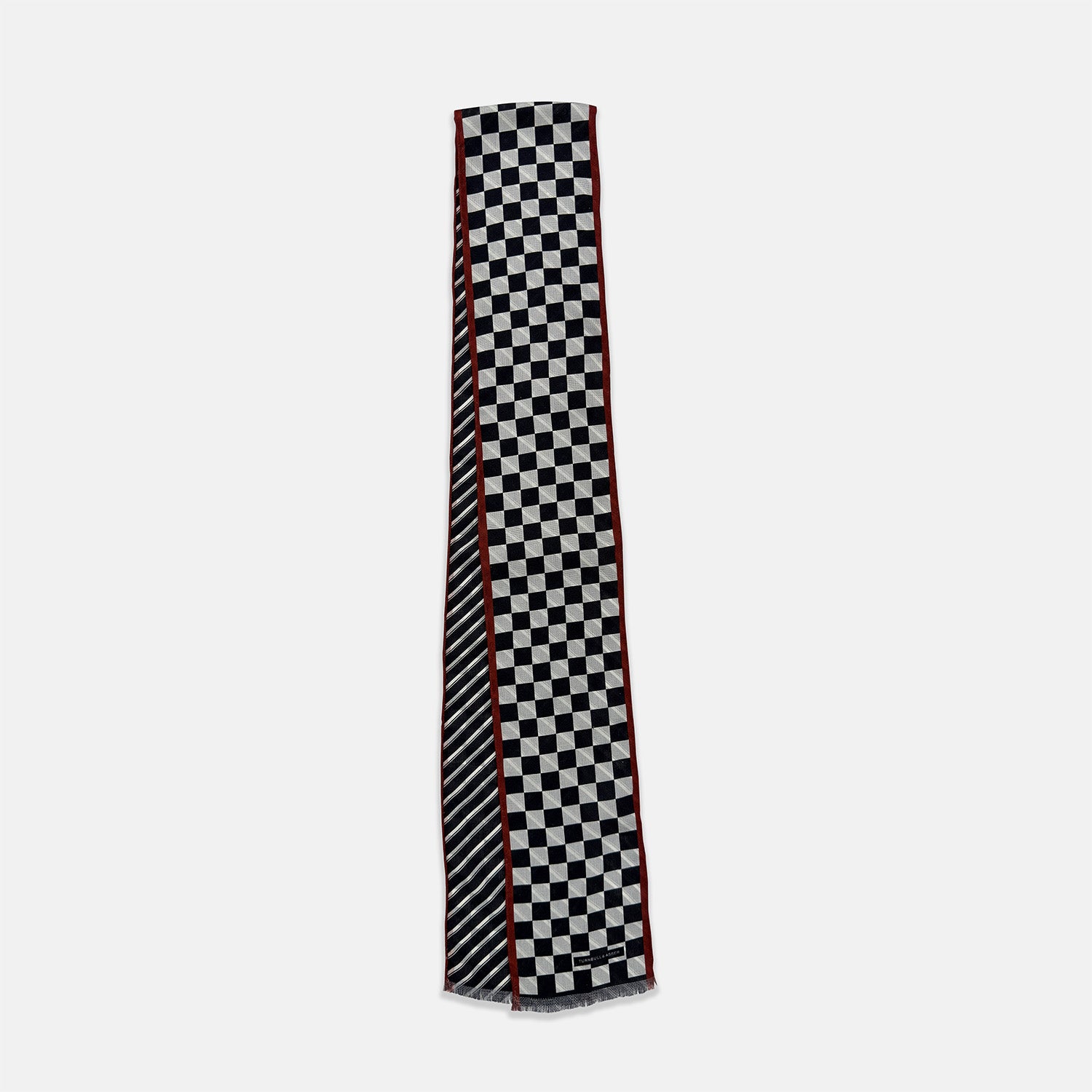 View 3 of product Introducing the Chequered Navy on Red Frame Small Scarf in Silk by Turnbull & Asser UK—a luxurious silk accessory featuring a navy and white chequered pattern, accented with thin red borders and delicate fringe at each end. Displayed against a white background, this scarf pays homage to British motoring heritage and the enduring elegance of Concours style.