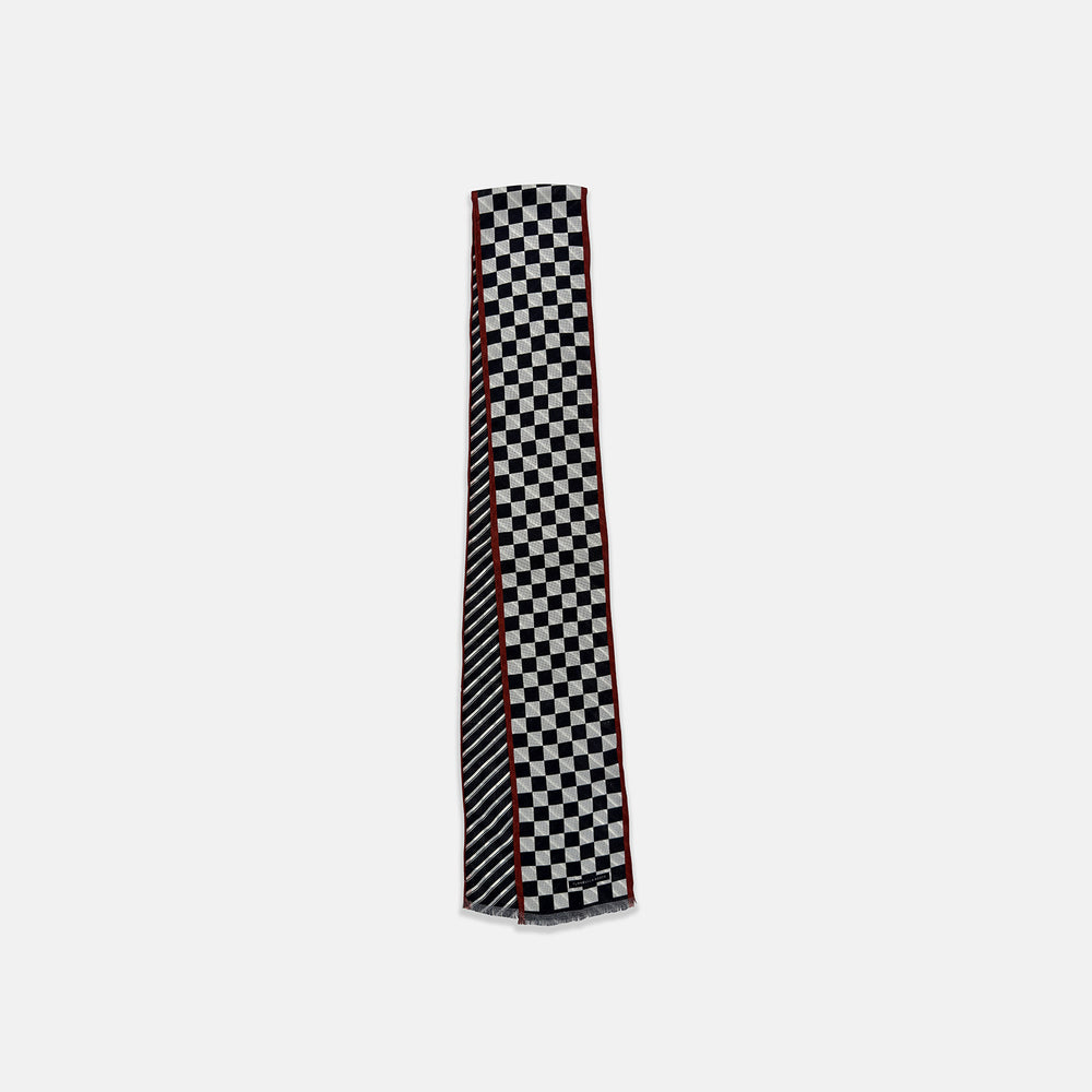 Introducing the Chequered Navy on Red Frame Small Scarf in Silk by Turnbull & Asser UK—a luxurious silk accessory featuring a navy and white chequered pattern, accented with thin red borders and delicate fringe at each end. Displayed against a white background, this scarf pays homage to British motoring heritage and the enduring elegance of Concours style.