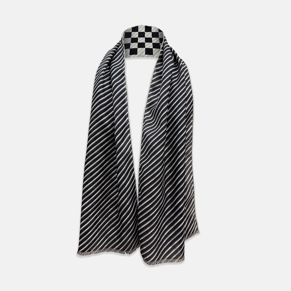 A Chequered Navy on White Frame Large Scarf in Silk from Turnbull & Asser UK, featuring a striking navy and white checkerboard motif inspired by classic British motoring heritage, is gracefully displayed over an invisible stand with its ends cascading downward and the top artfully folded into a striped semicircle—an impeccable choice for making a stylish statement at the Concours of Elegance 2026.
