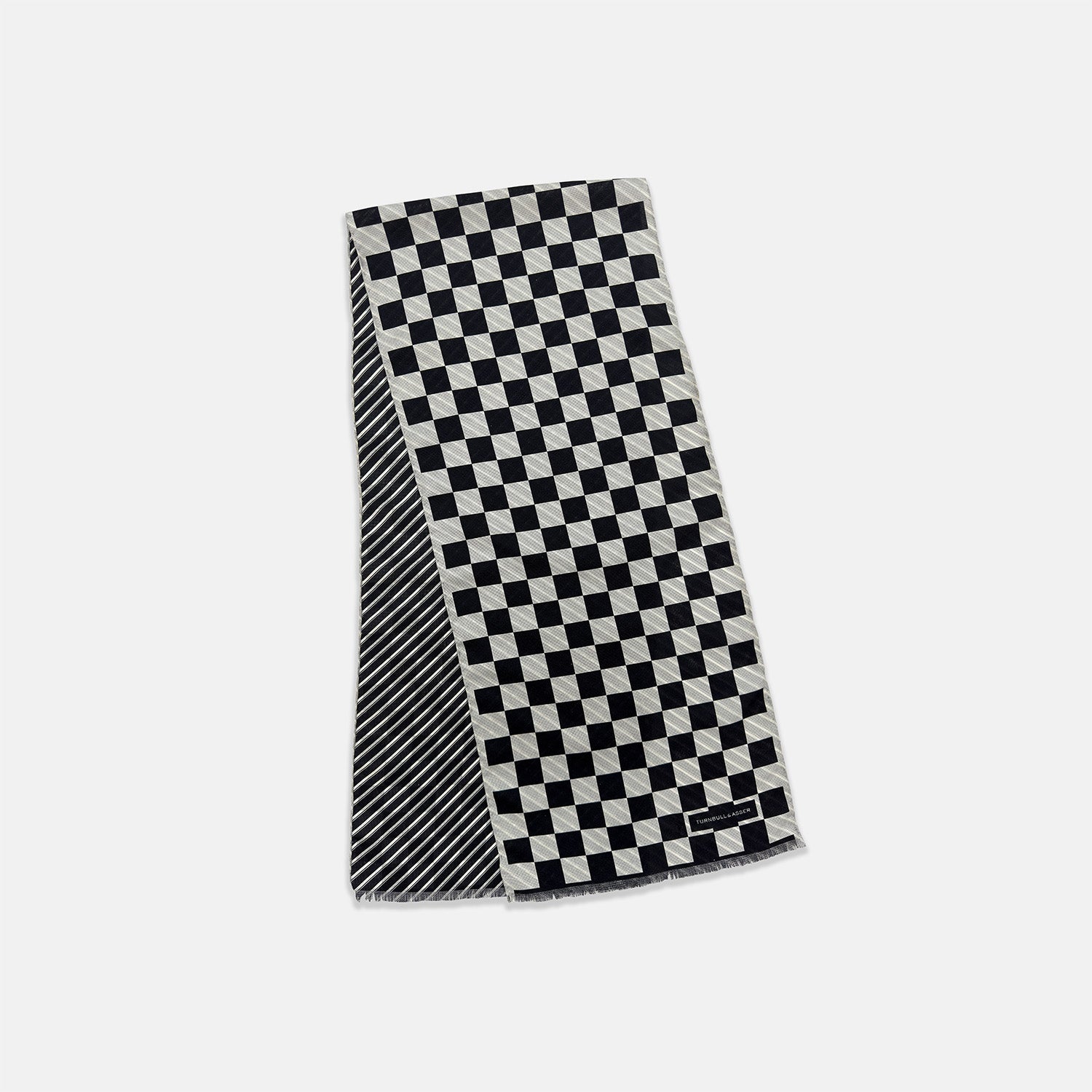 View 3 of product A Chequered Navy on White Frame Large Scarf in Silk from Turnbull & Asser UK, featuring a striking navy and white checkerboard motif inspired by classic British motoring heritage, is gracefully displayed over an invisible stand with its ends cascading downward and the top artfully folded into a striped semicircle—an impeccable choice for making a stylish statement at the Concours of Elegance 2026.