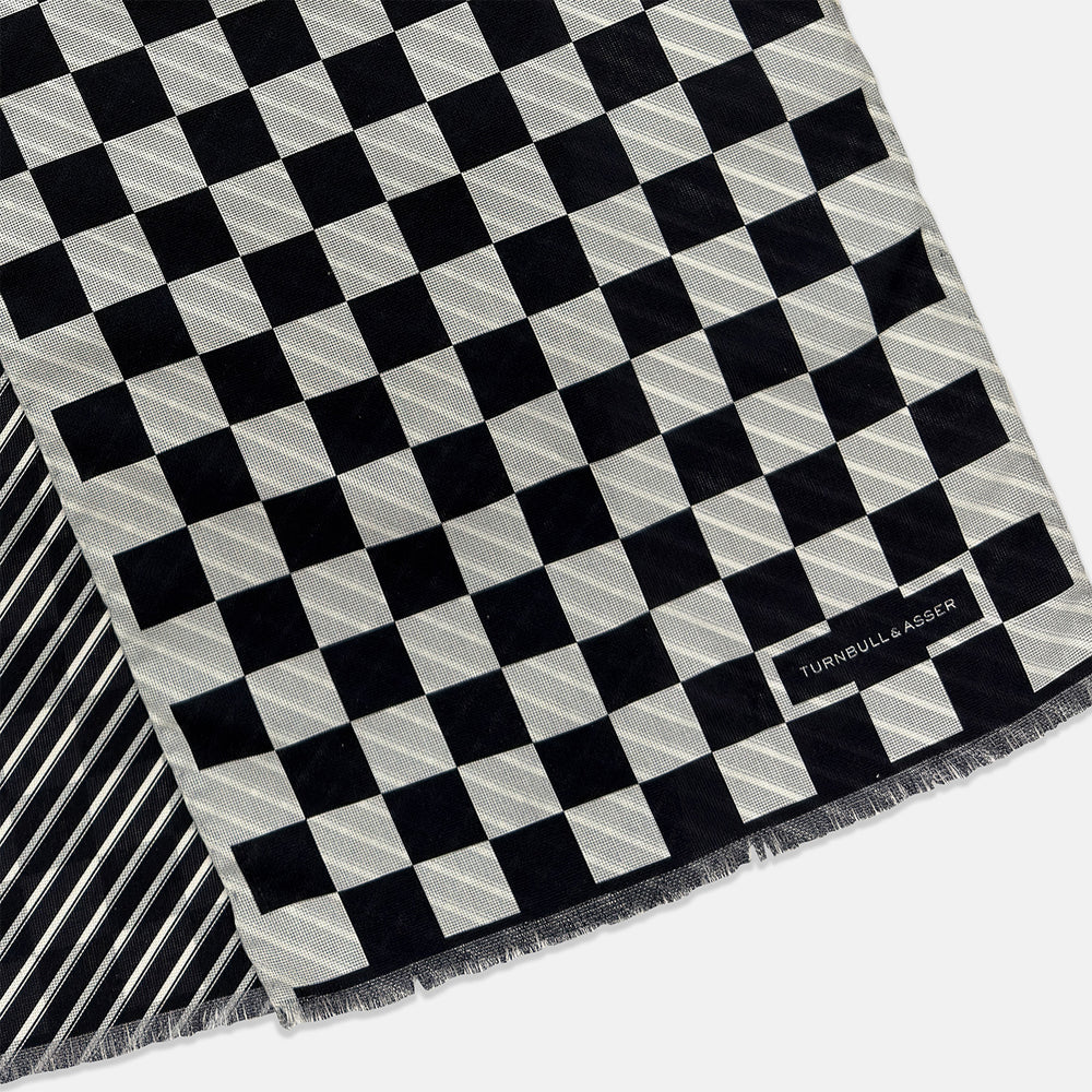 A Chequered Navy on White Frame Large Scarf in Silk from Turnbull & Asser UK, featuring a striking navy and white checkerboard motif inspired by classic British motoring heritage, is gracefully displayed over an invisible stand with its ends cascading downward and the top artfully folded into a striped semicircle—an impeccable choice for making a stylish statement at the Concours of Elegance 2026.